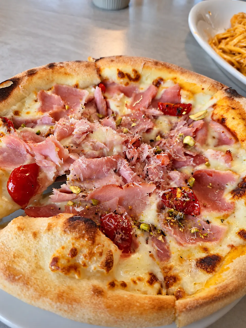 Jambon pizza topped with jambon and pistachios
