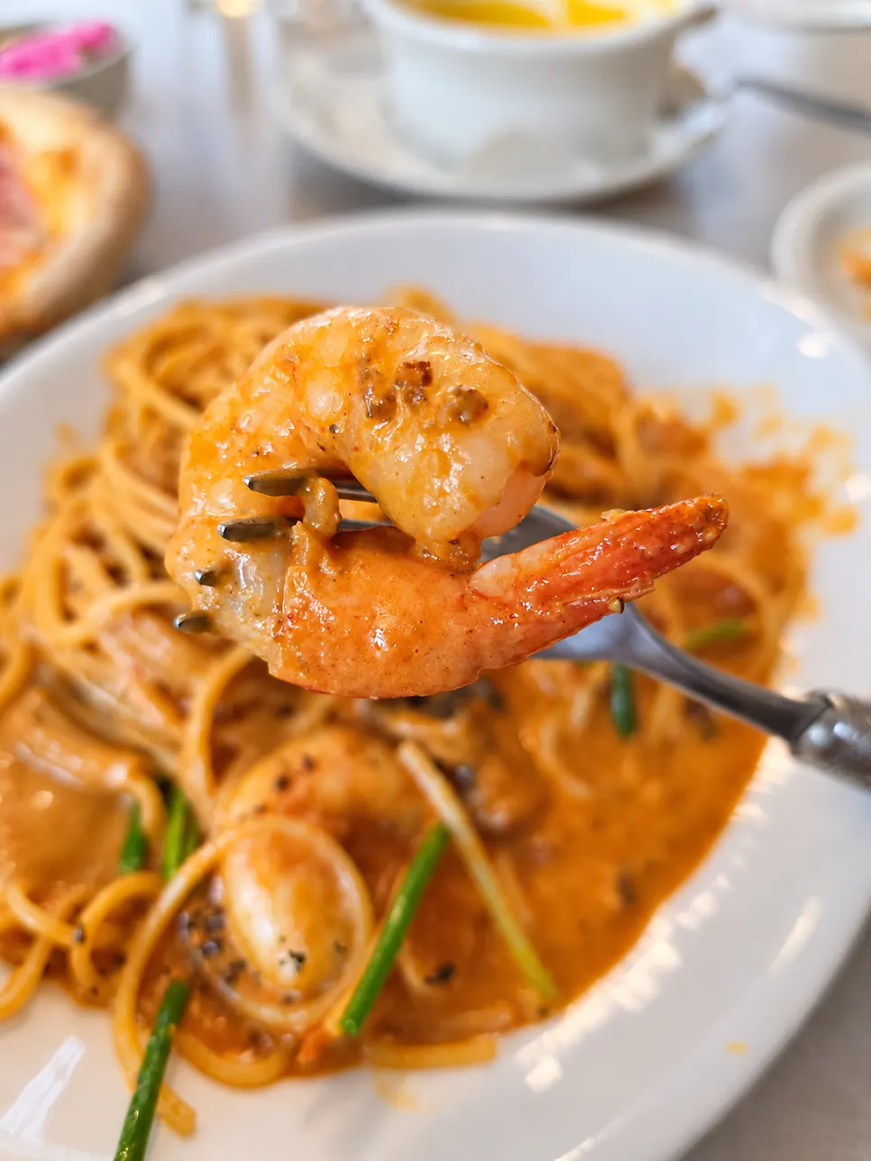 Big rosé-sauce shrimp held on a fork