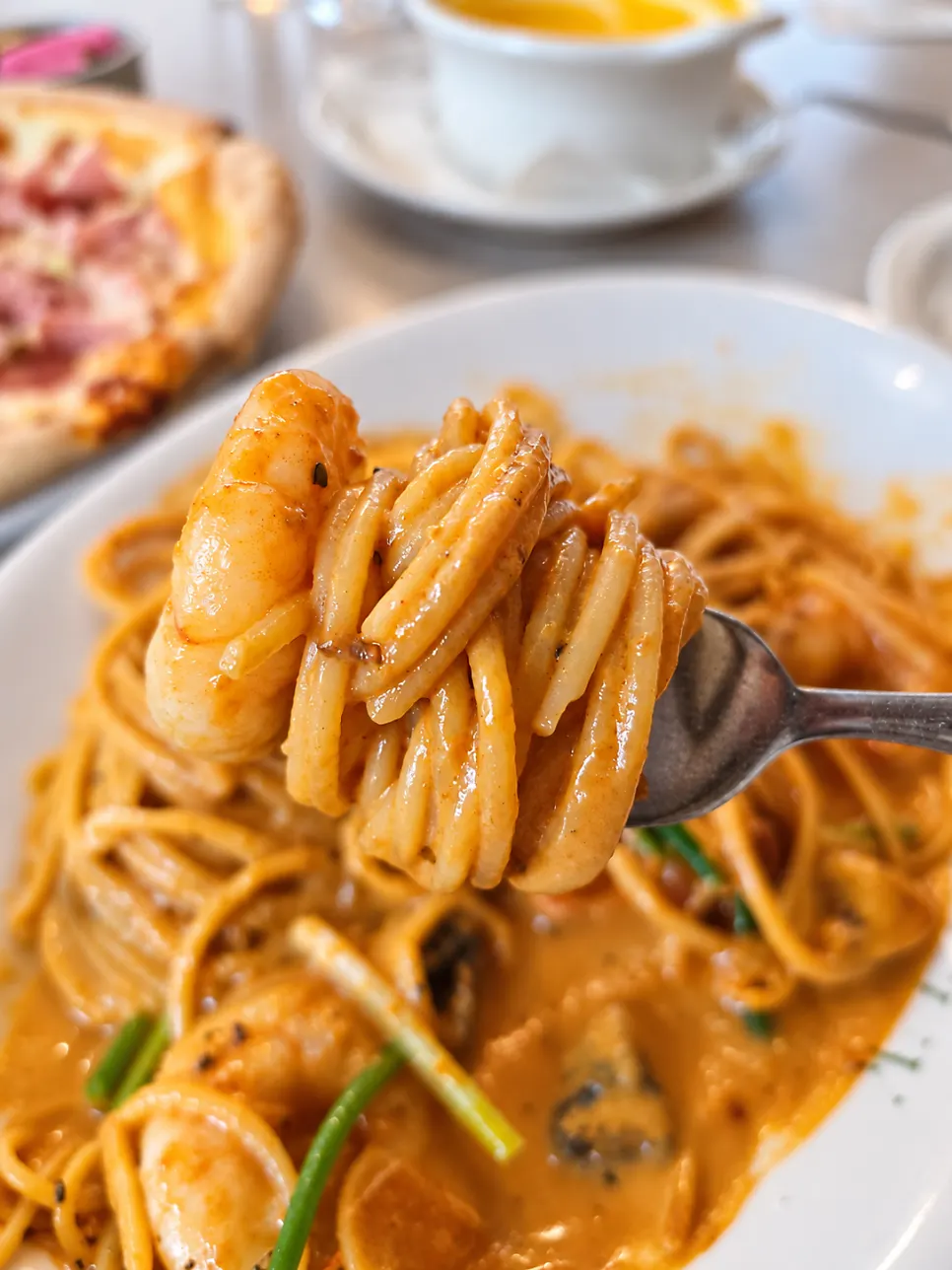 Fork holding rosé-sauce noodles and shrimp