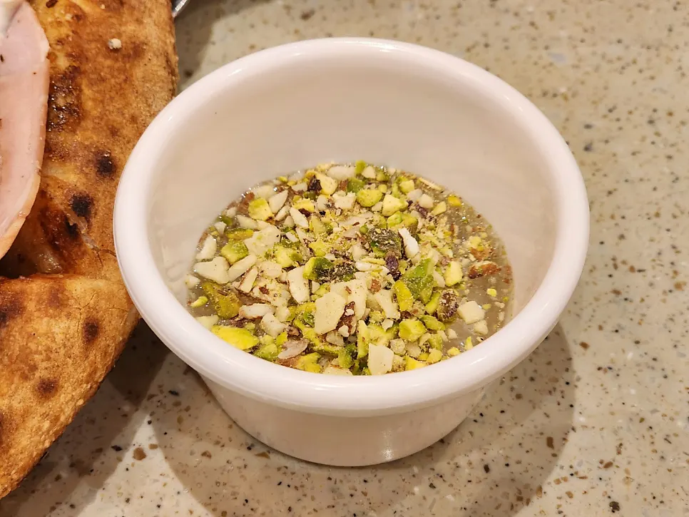 Honey sprinkled with pistachio, served with a pizza plate