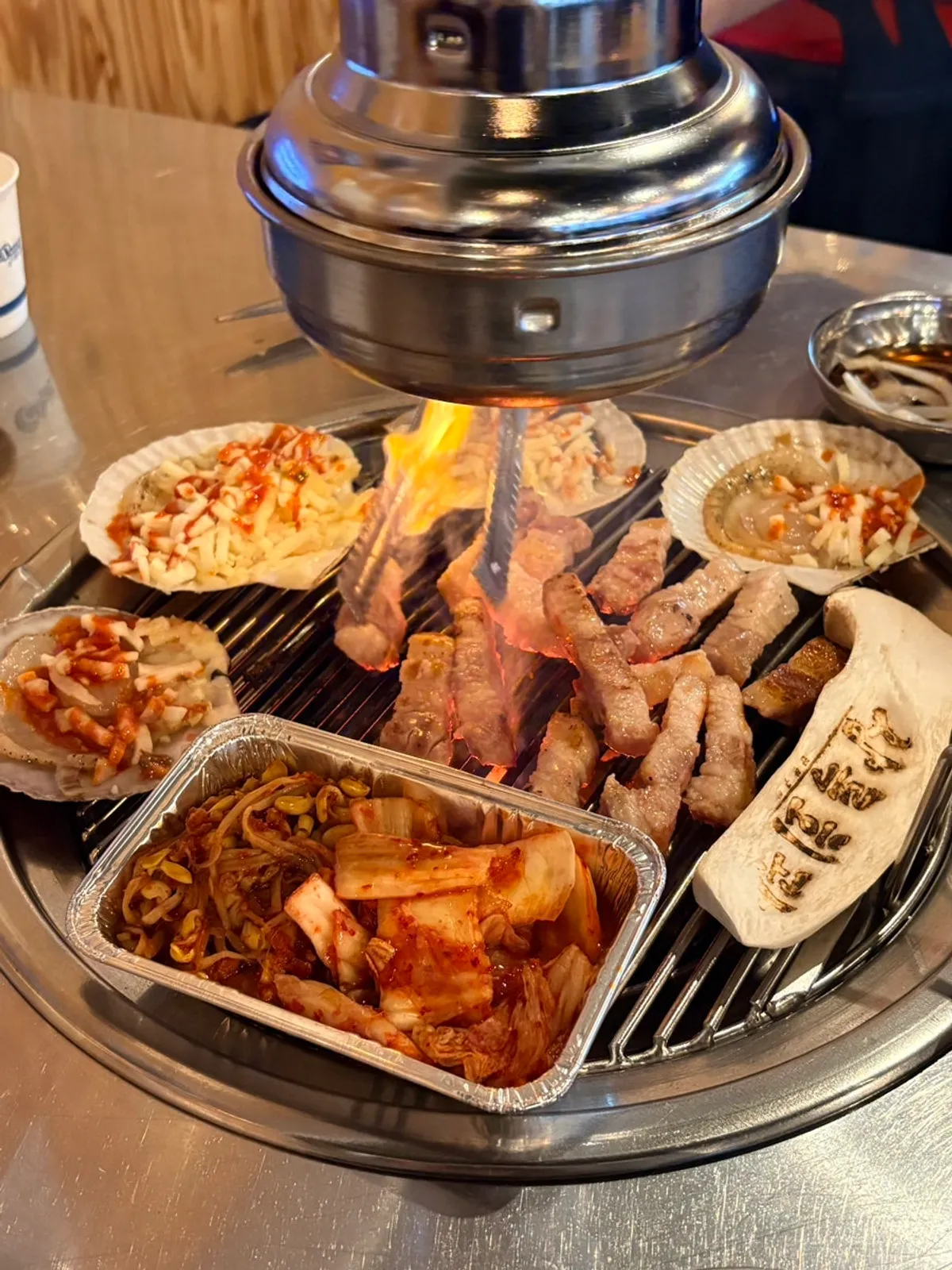 Pork belly and cheese scallops cooking together over charcoal