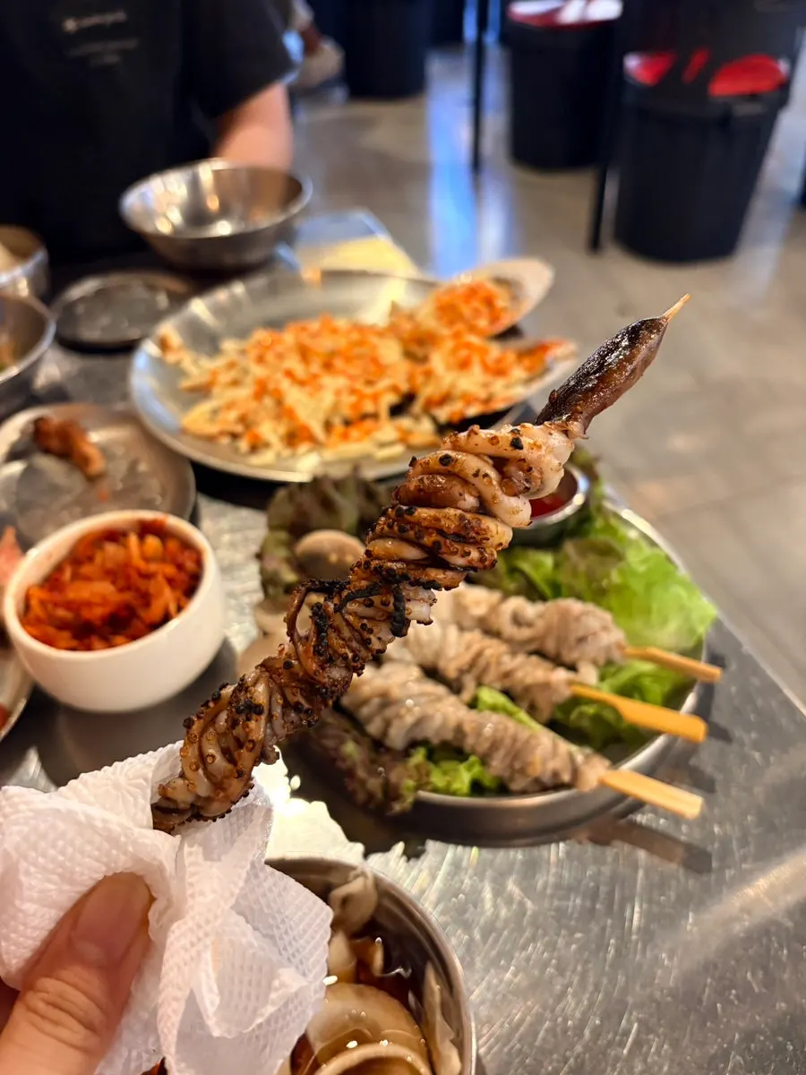 Grilled octopus skewers cooking gently over charcoal