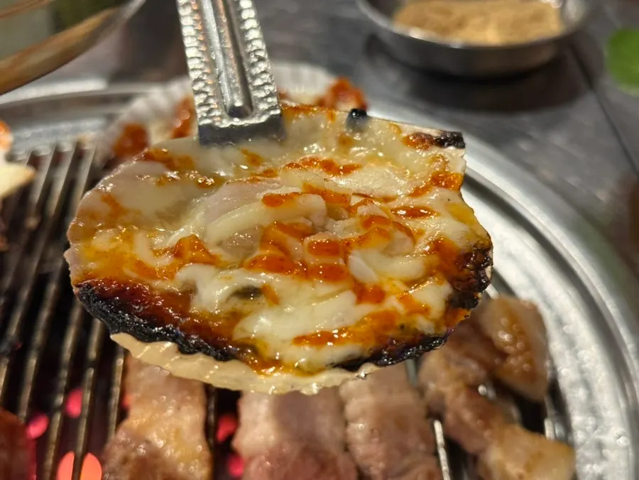 A large scallop piled high with cheese