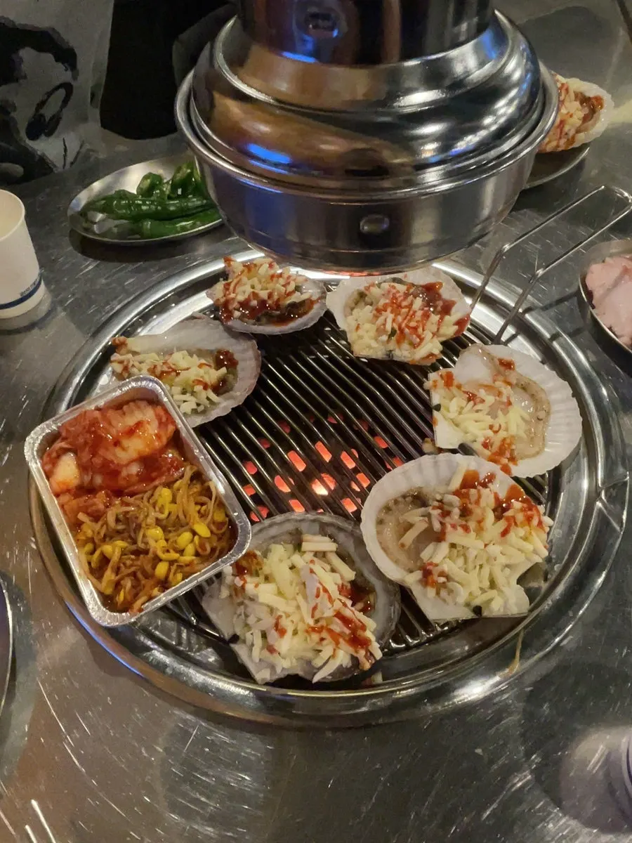 Meat and scallops placed on the charcoal grill