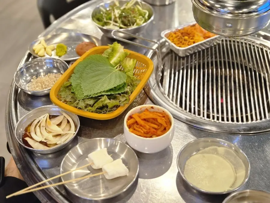 Basic table setting of bean sprouts and kimchi in foil dishes
