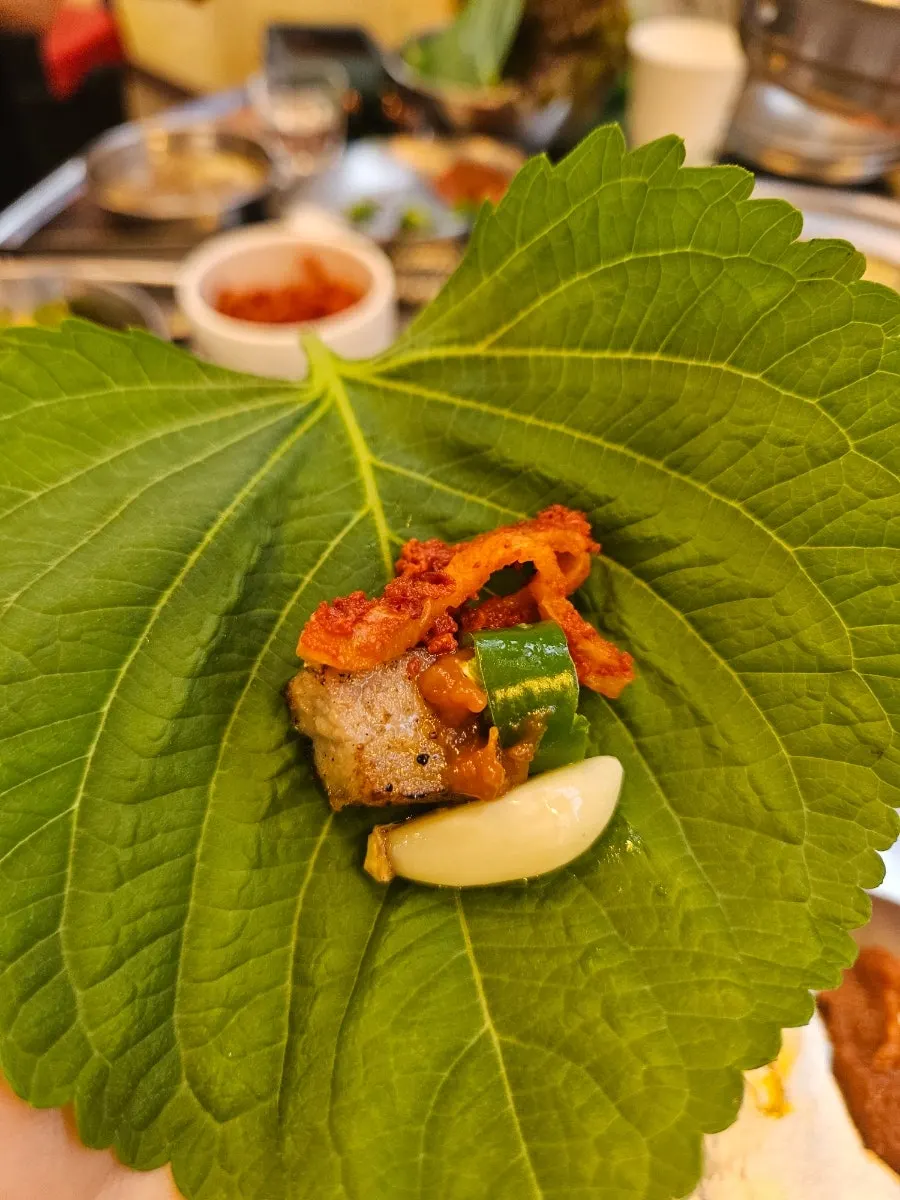 A piece of meat paired with grilled bean sprouts