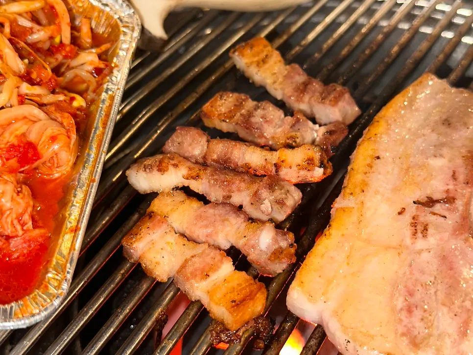 Pork belly cooking over the charcoal grill