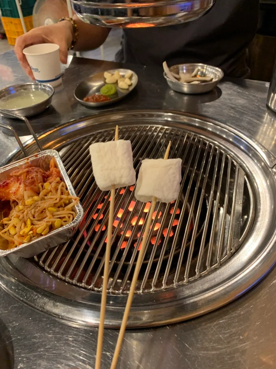 Side dishes of scallion salad, pickled radish, onion sauce, bean sprouts, and kimchi