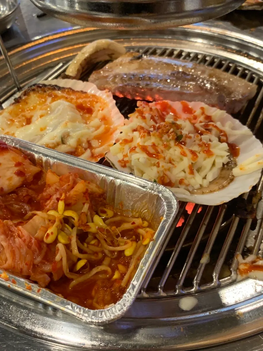 Grill with meat and scallops cooking together
