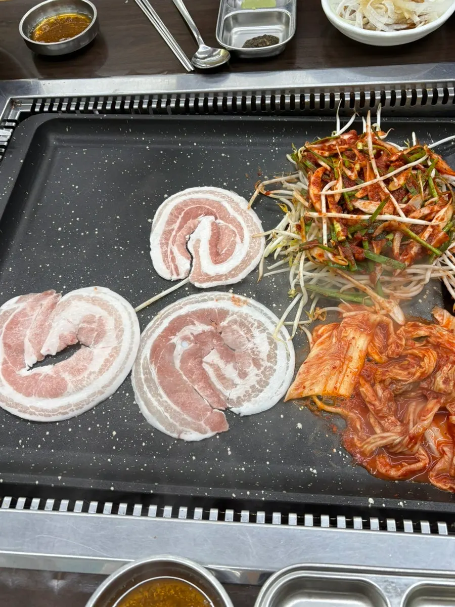 Frozen pork belly cooking on the grill