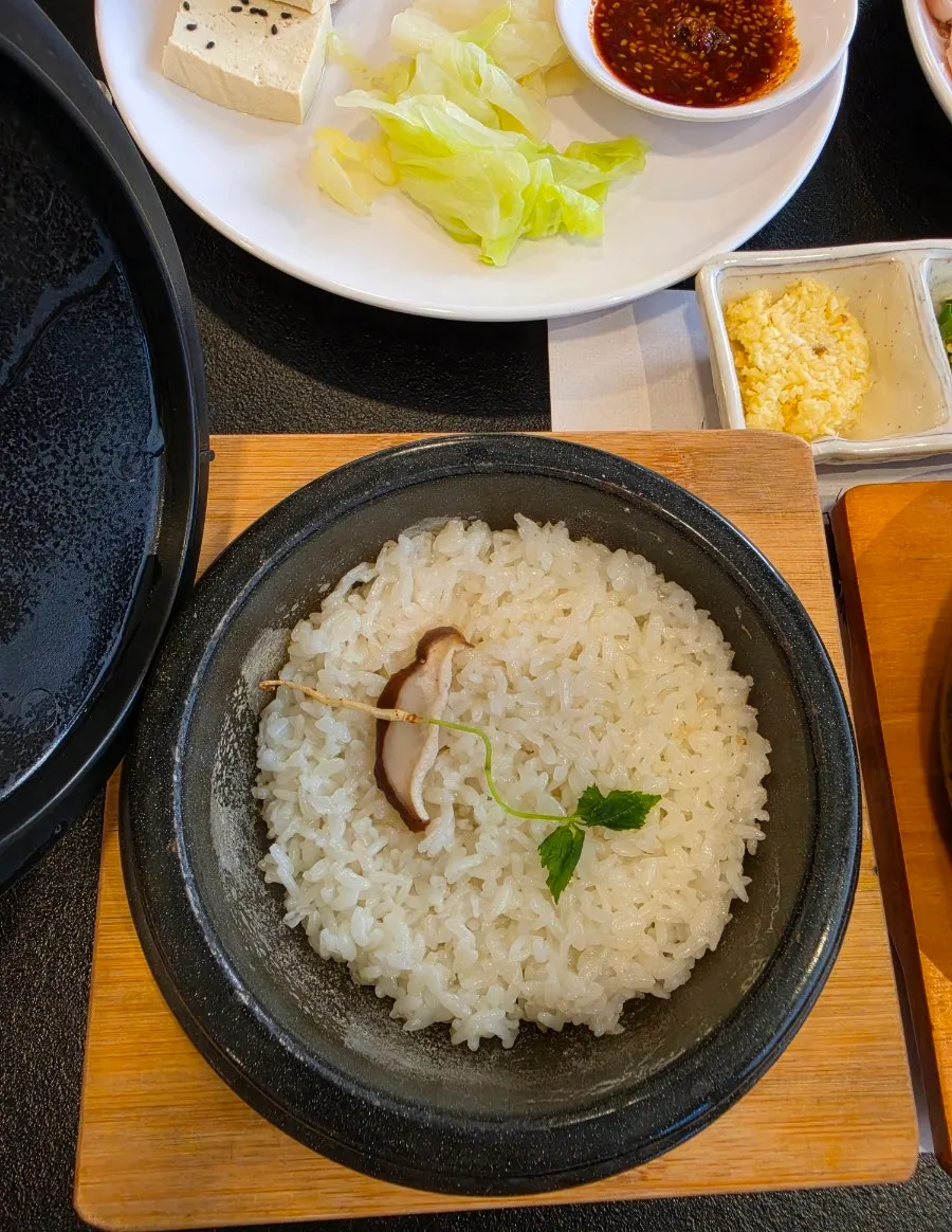 Pot rice topped with ginseng and mushrooms at Sangol Chueojeong