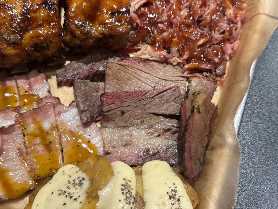 A BBQ platter topped with pulled pork