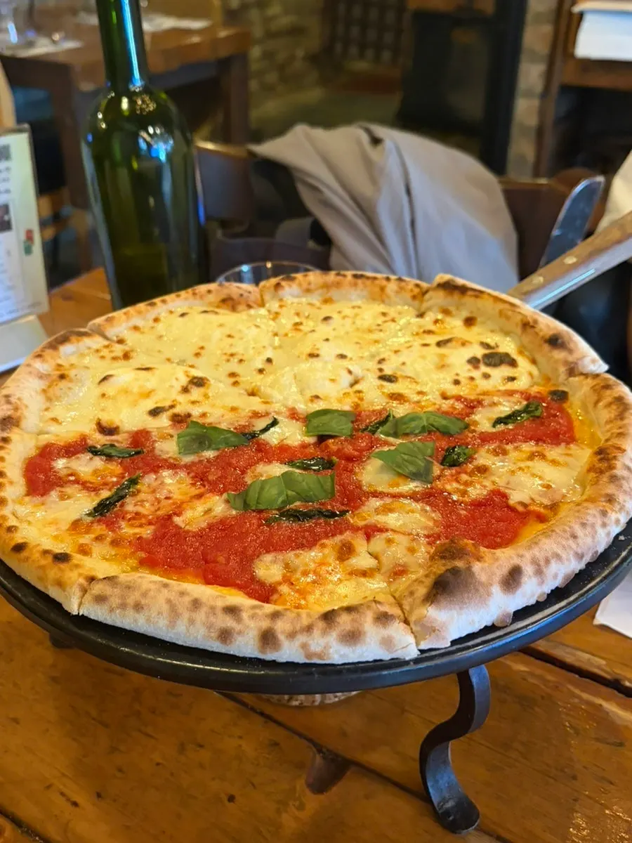 Kiosk screen showing the wood-fired pizza menu and half-and-half option