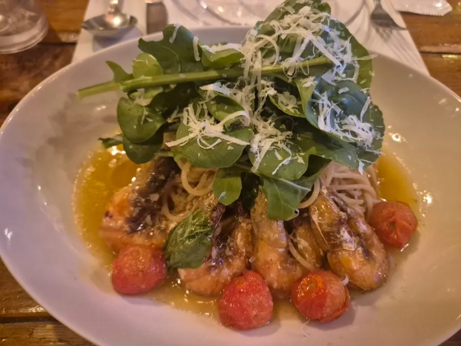 A plate of Gamberi e Rucola oil pasta