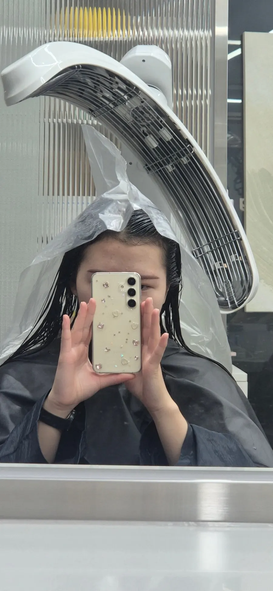 Plastic wrap placed over hair with solution while using the heat treatment machine
