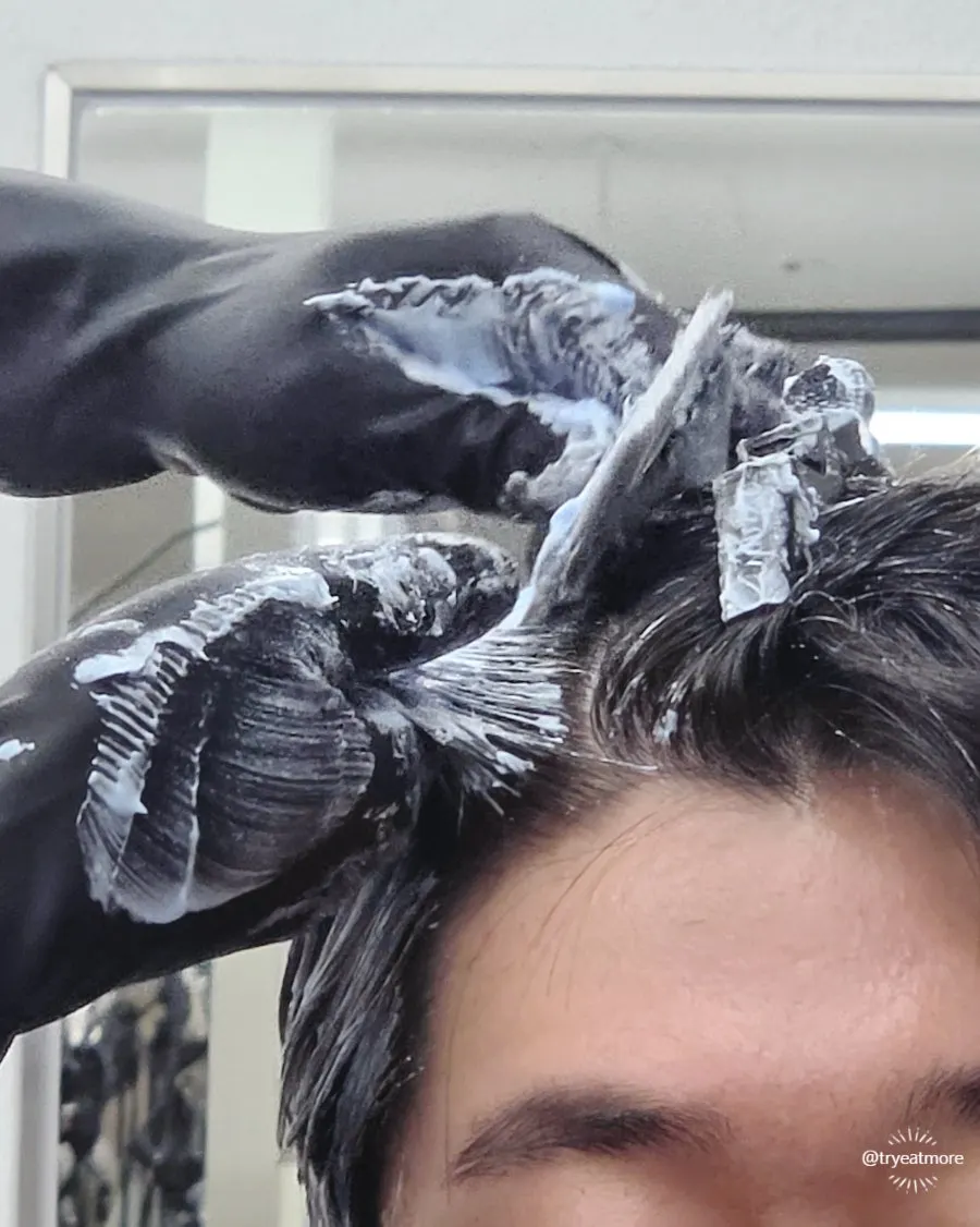 Bleach being applied to hair with a duck-shaped decoration nearby
