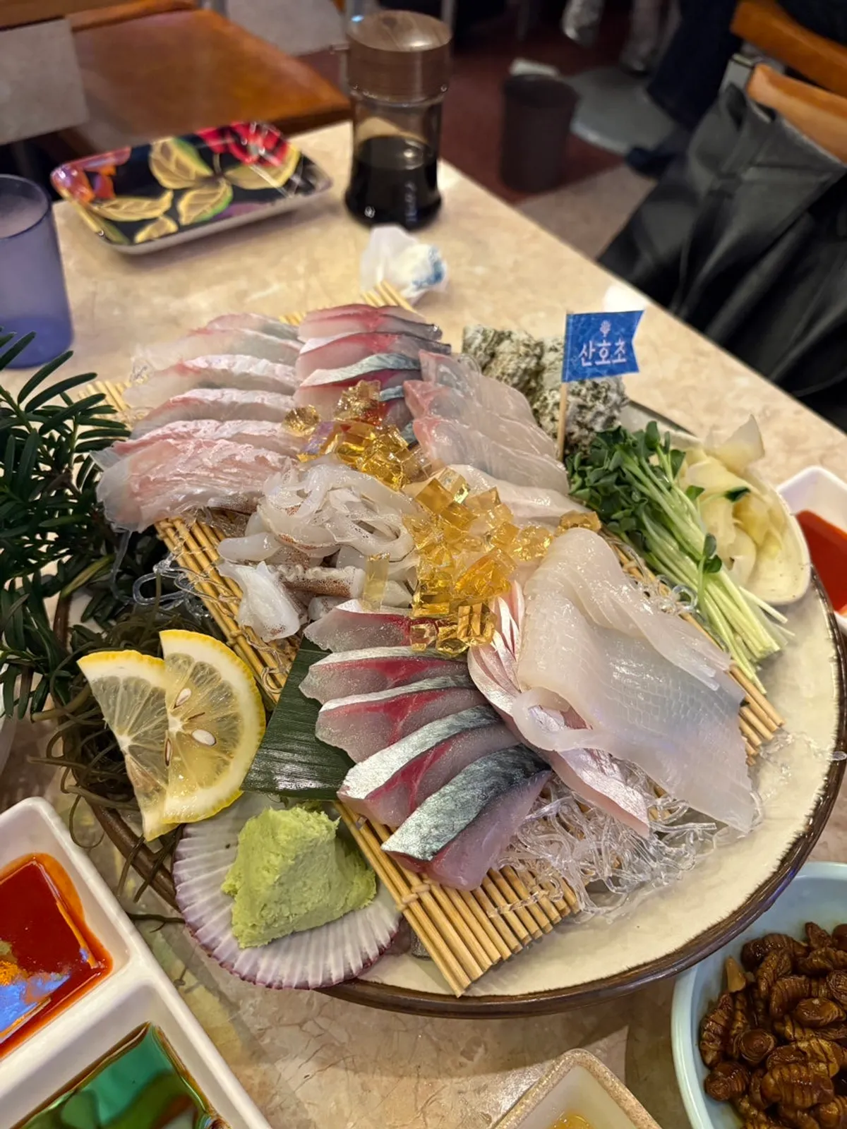 A plate of the 3-type sashimi: live mackerel, live squid, and big flounder