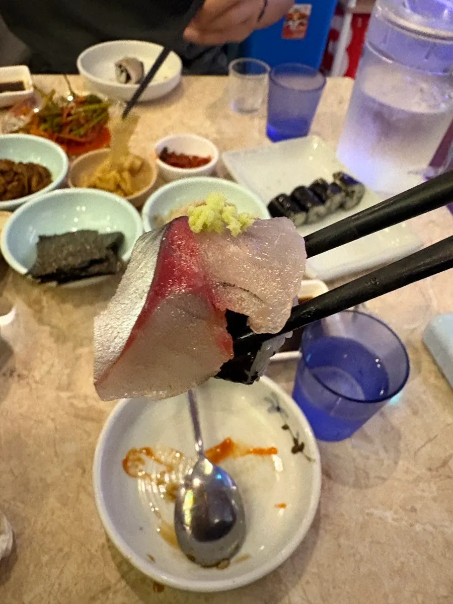 Picking up a piece of mackerel sashimi