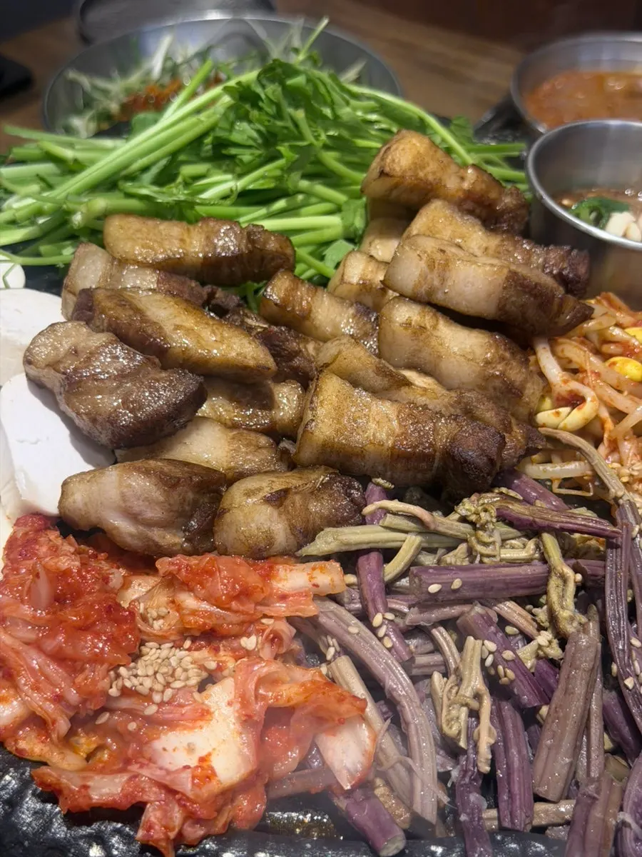 Minari piled onto golden-browned pork belly