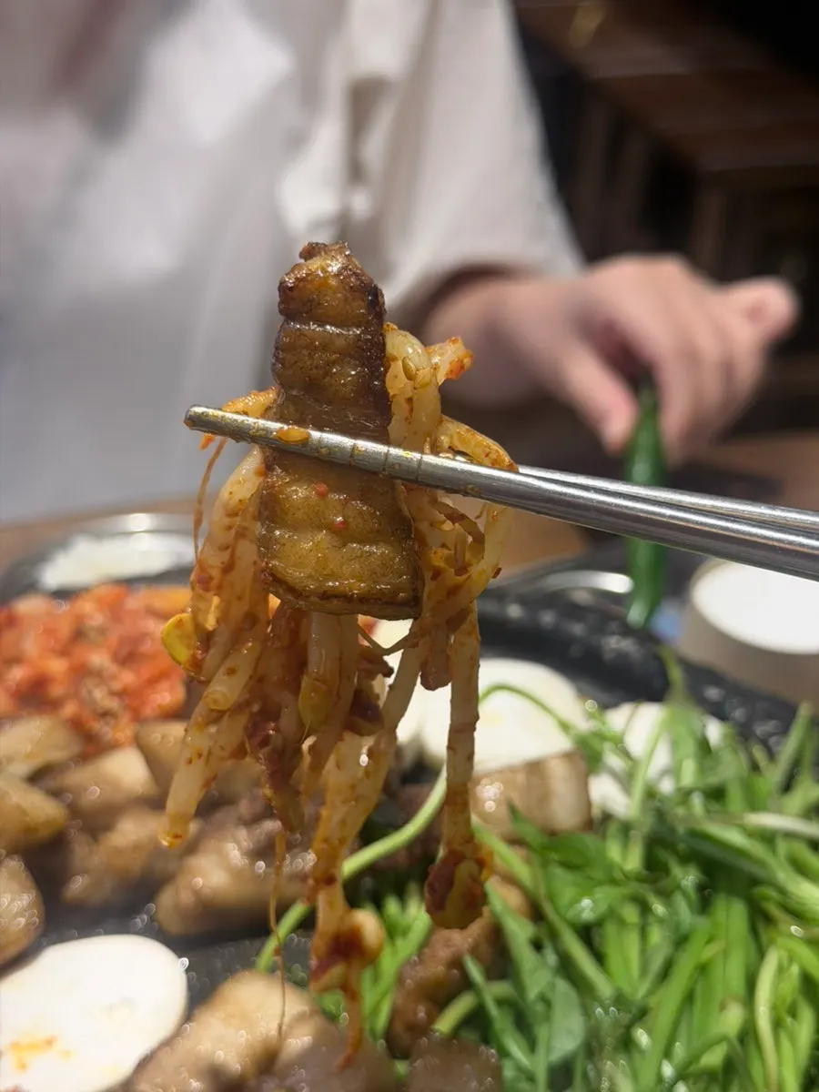 Pork belly wrap topped with grilled minari
