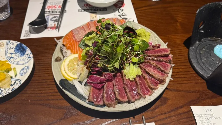 厚切りにされた生サーモンと牛タタキの皿