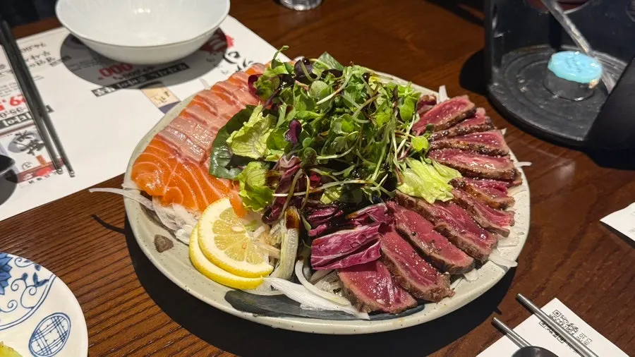 サラダと玉ねぎが一緒に盛られた刺身プレート