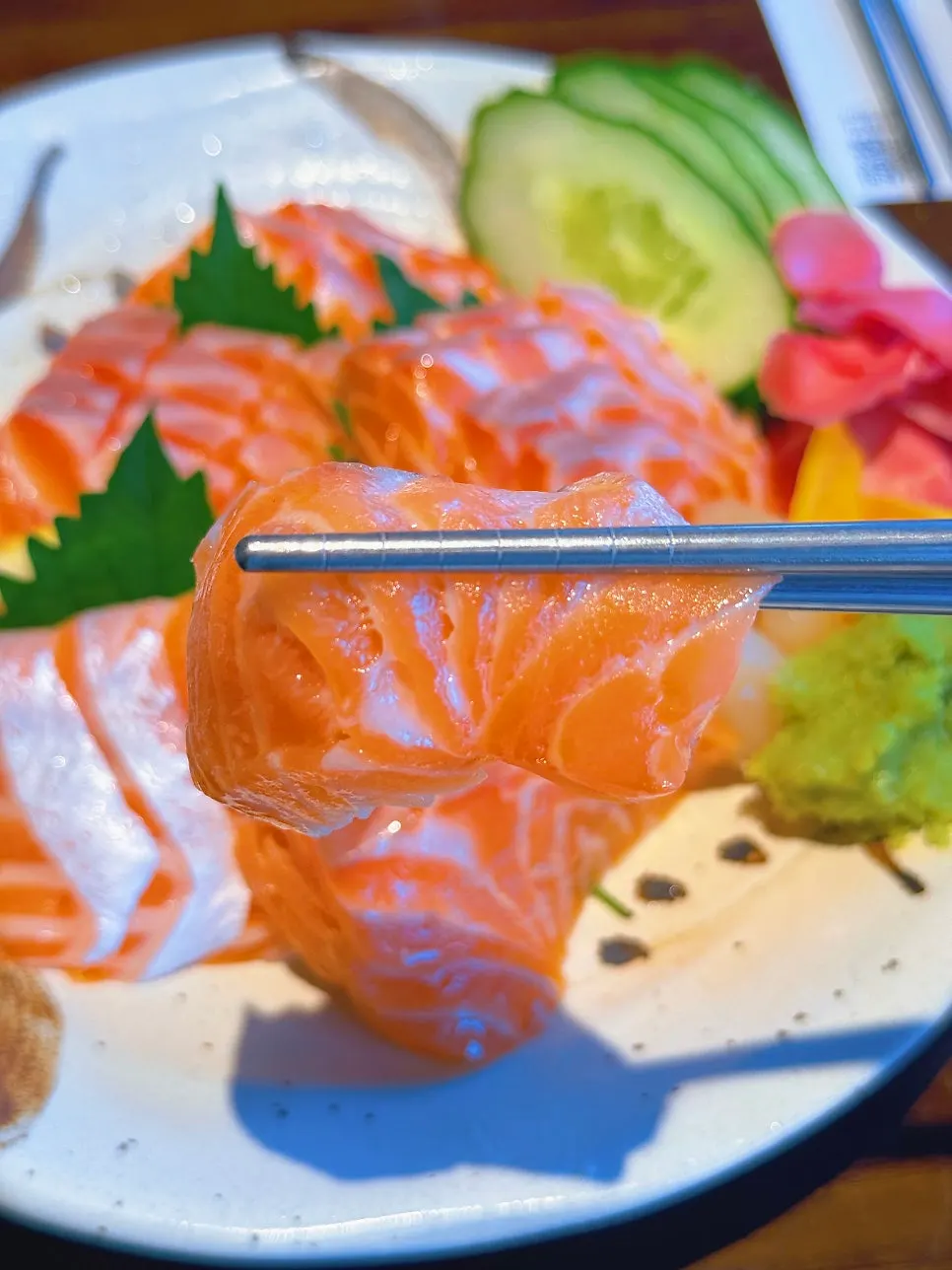 A piece of salmon with cucumber garnish