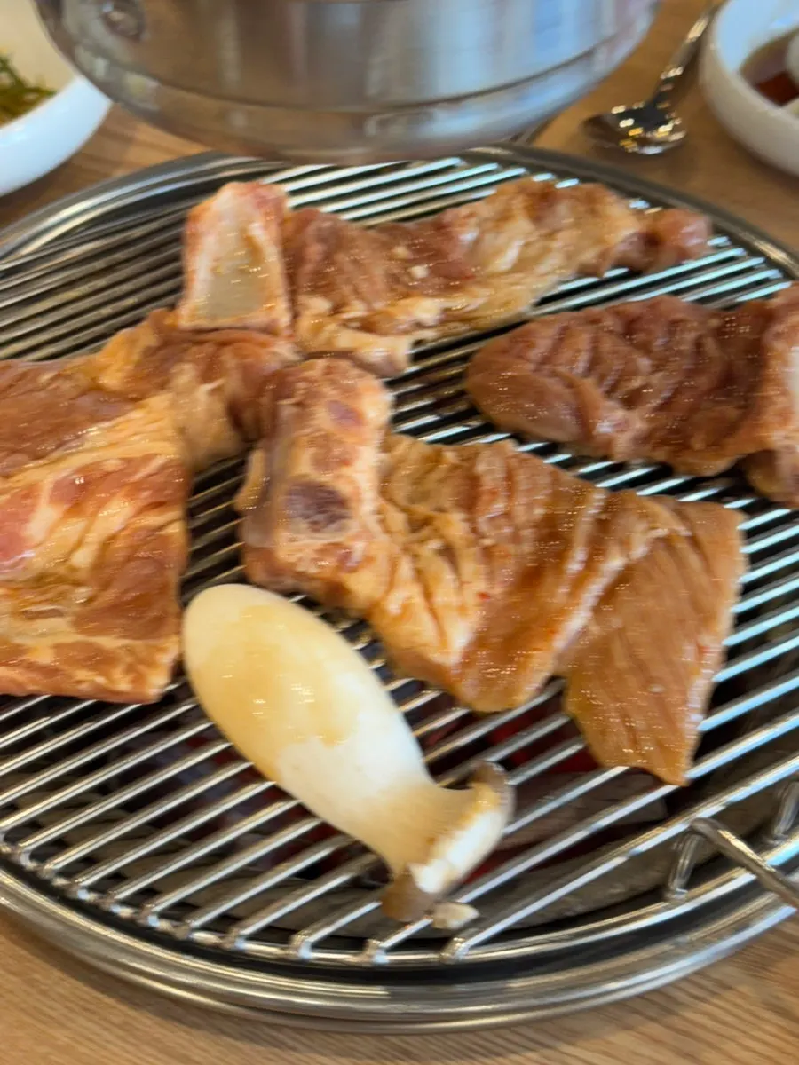 Seasoned pork galbi cooking over charcoal