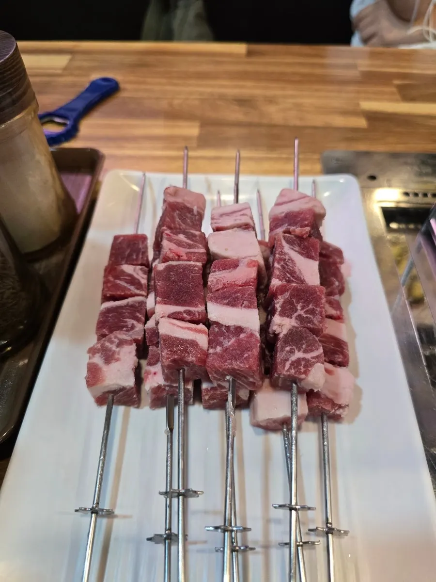 Ordered lamb skewers with side dishes on the table