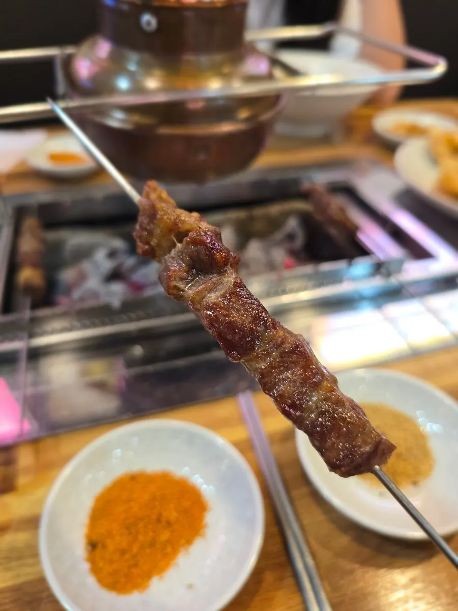 Close-up of a single grilled lamb skewer