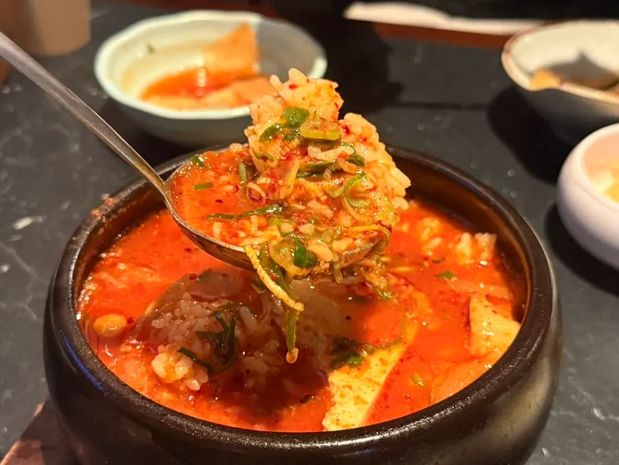 Kimchi jjigae broth with a rosé-like tint