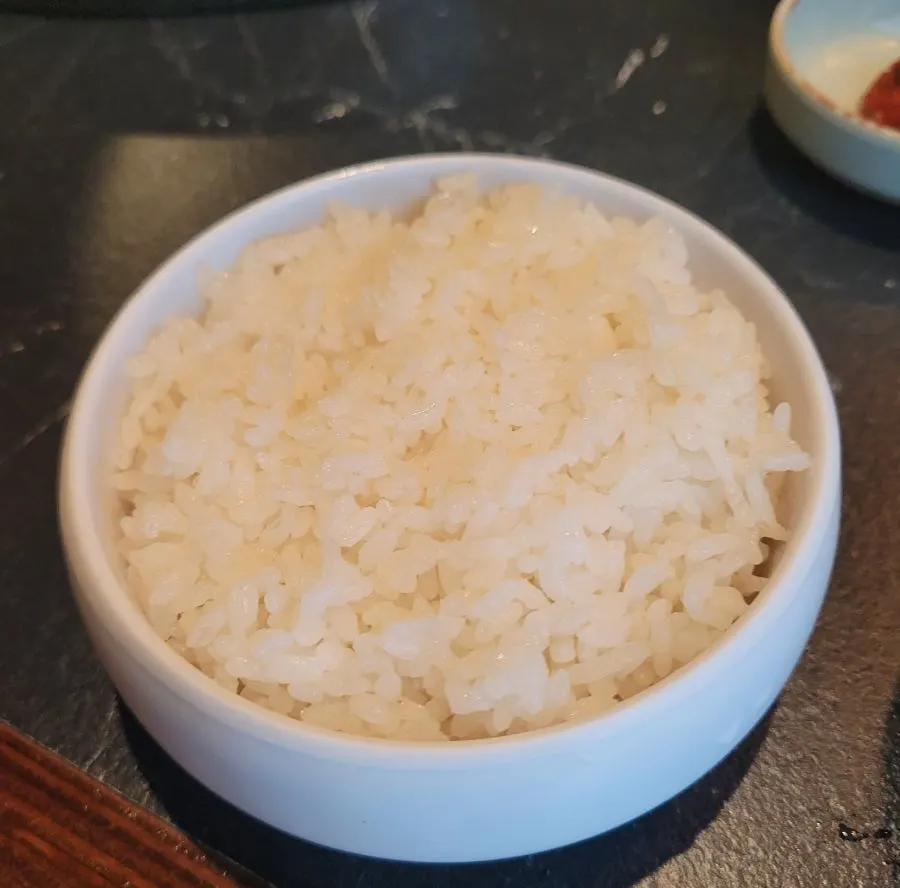 삼겹살과 김치찌개, 공기밥이 함께 차려진 테이블