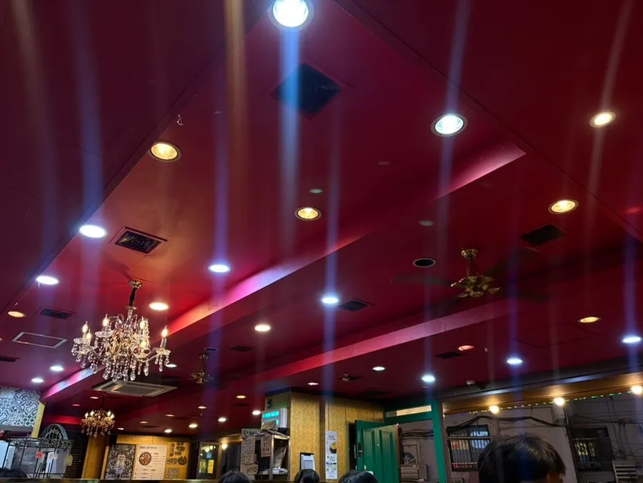 Sarangjip's interior with a cherry-red ceiling and chandelier