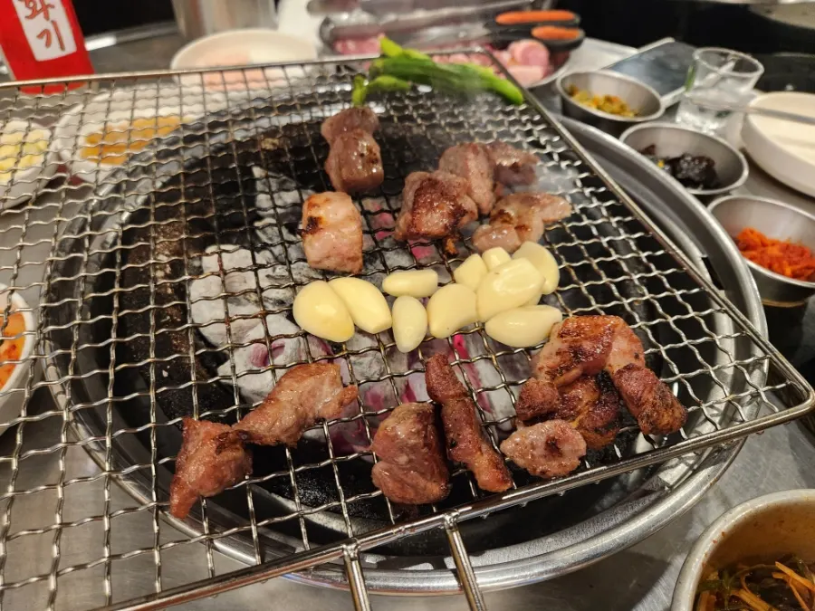 A bottle of soju with grilled meat