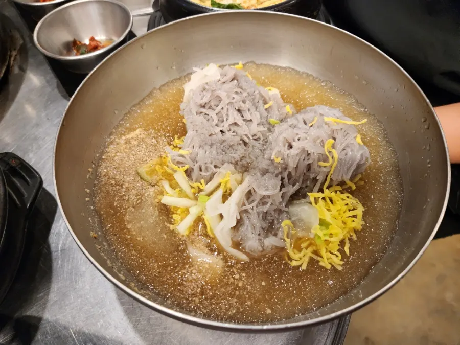 A bite of meat wrapped with green onion shreds