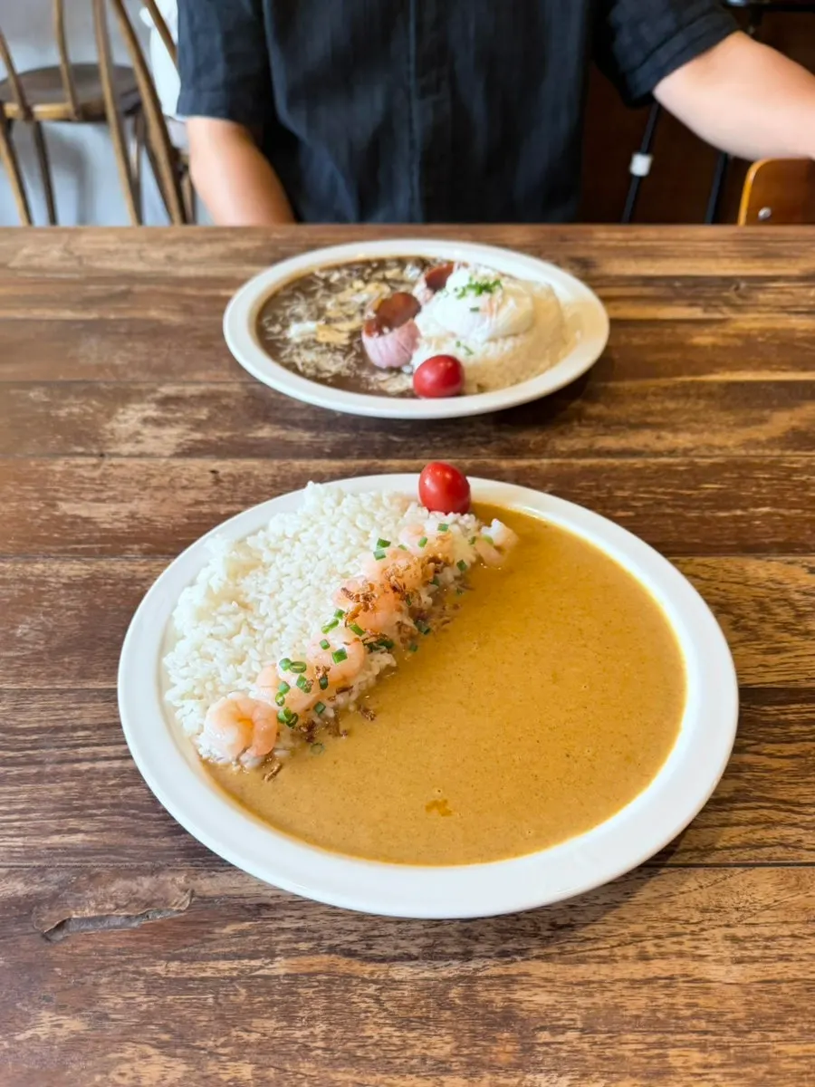 Two plates of curry arriving quickly after ordering