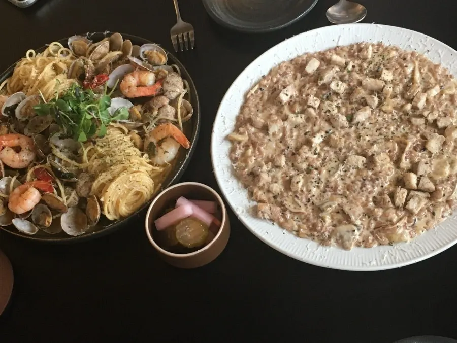 注文したパスタとリゾットが並んだテーブル