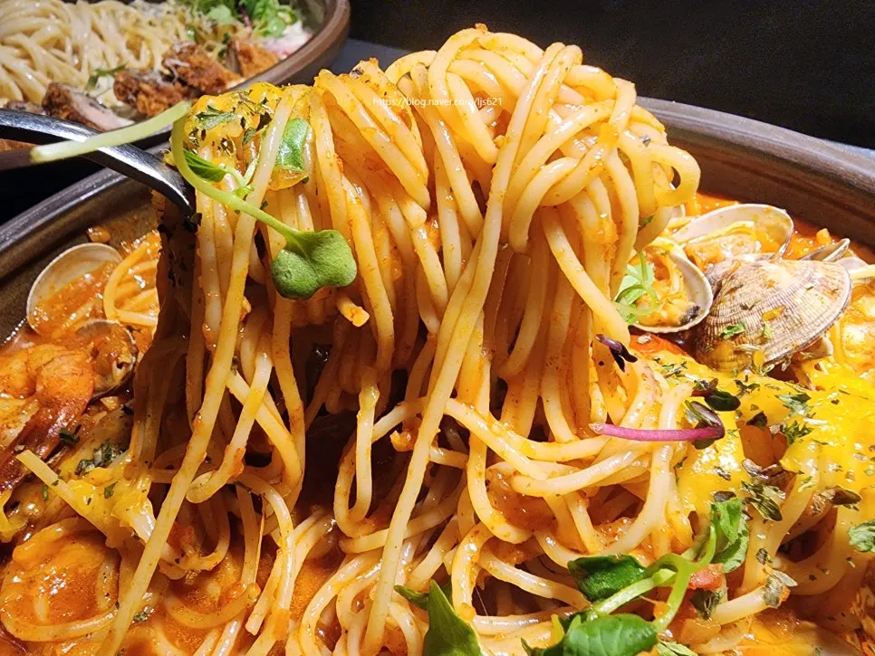 Twirling up pasta noodles coated in tomato sauce