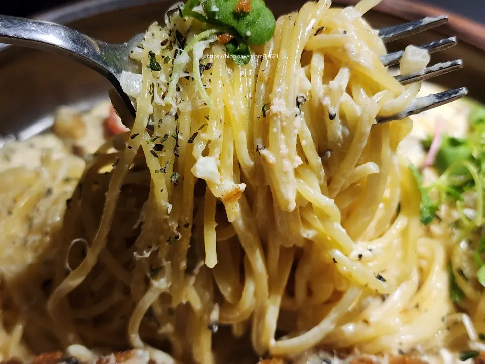Lifting up the thick, creamy pasta noodles