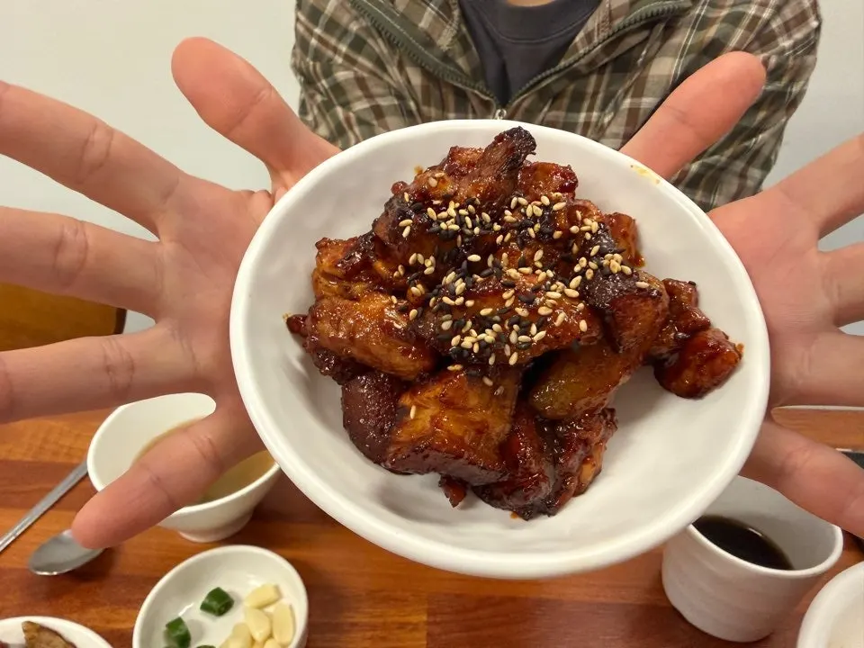족발 한 덩이를 손으로 들고 먹는 모습