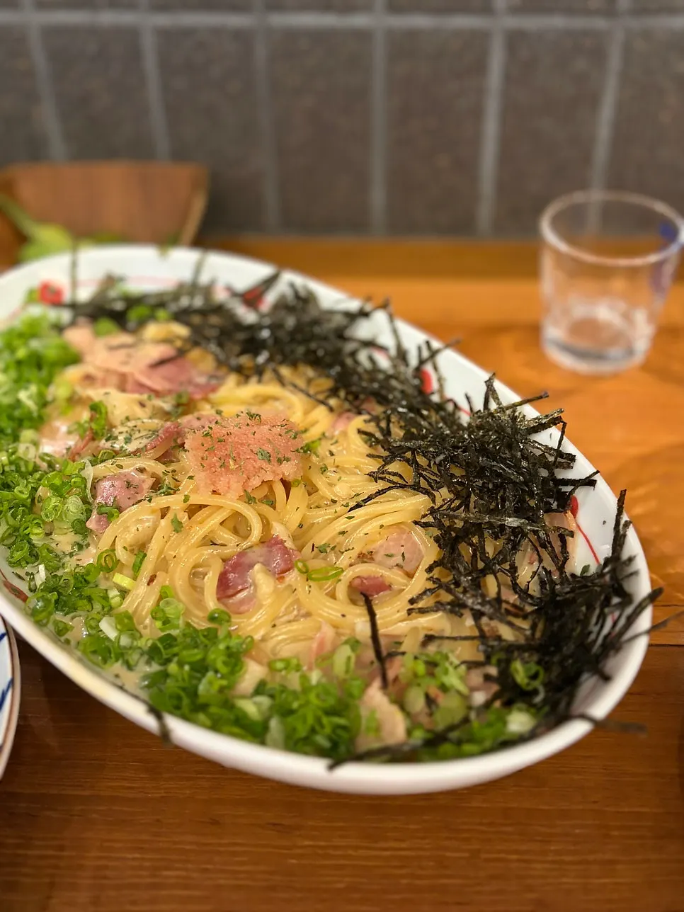 Mentaiko cream pasta topped with scallions and seaweed