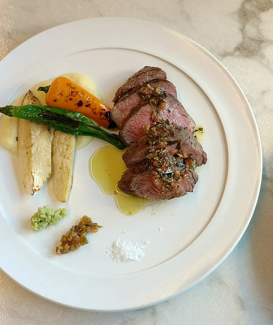 Steak served with chimichurri sauce and grilled vegetables