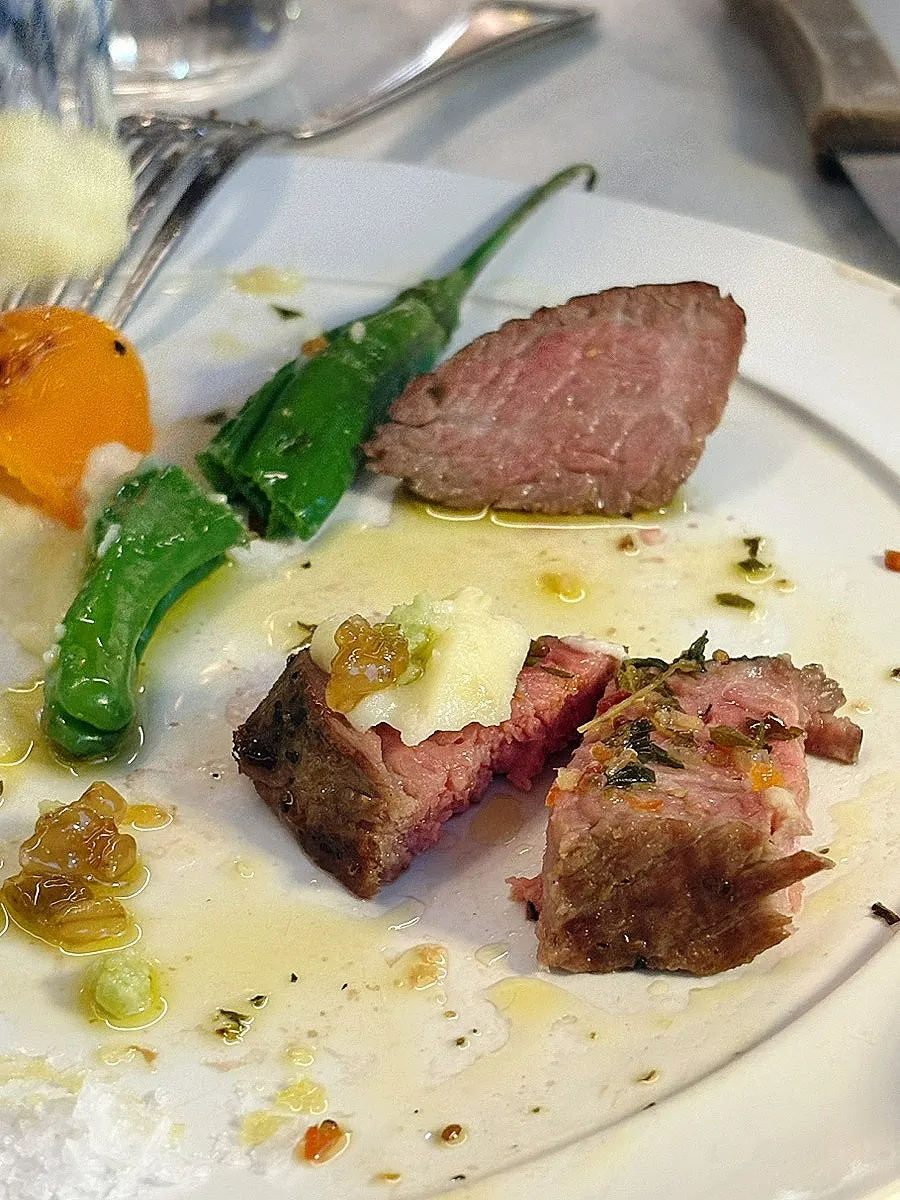 A piece of steak placed on top of the cream pasta