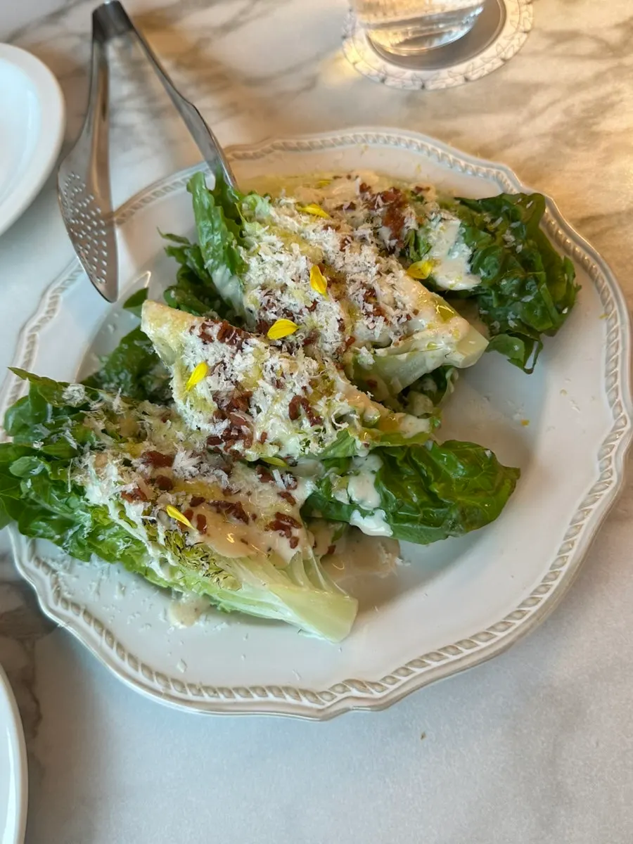 Caesar salad topped with a whole head of romaine
