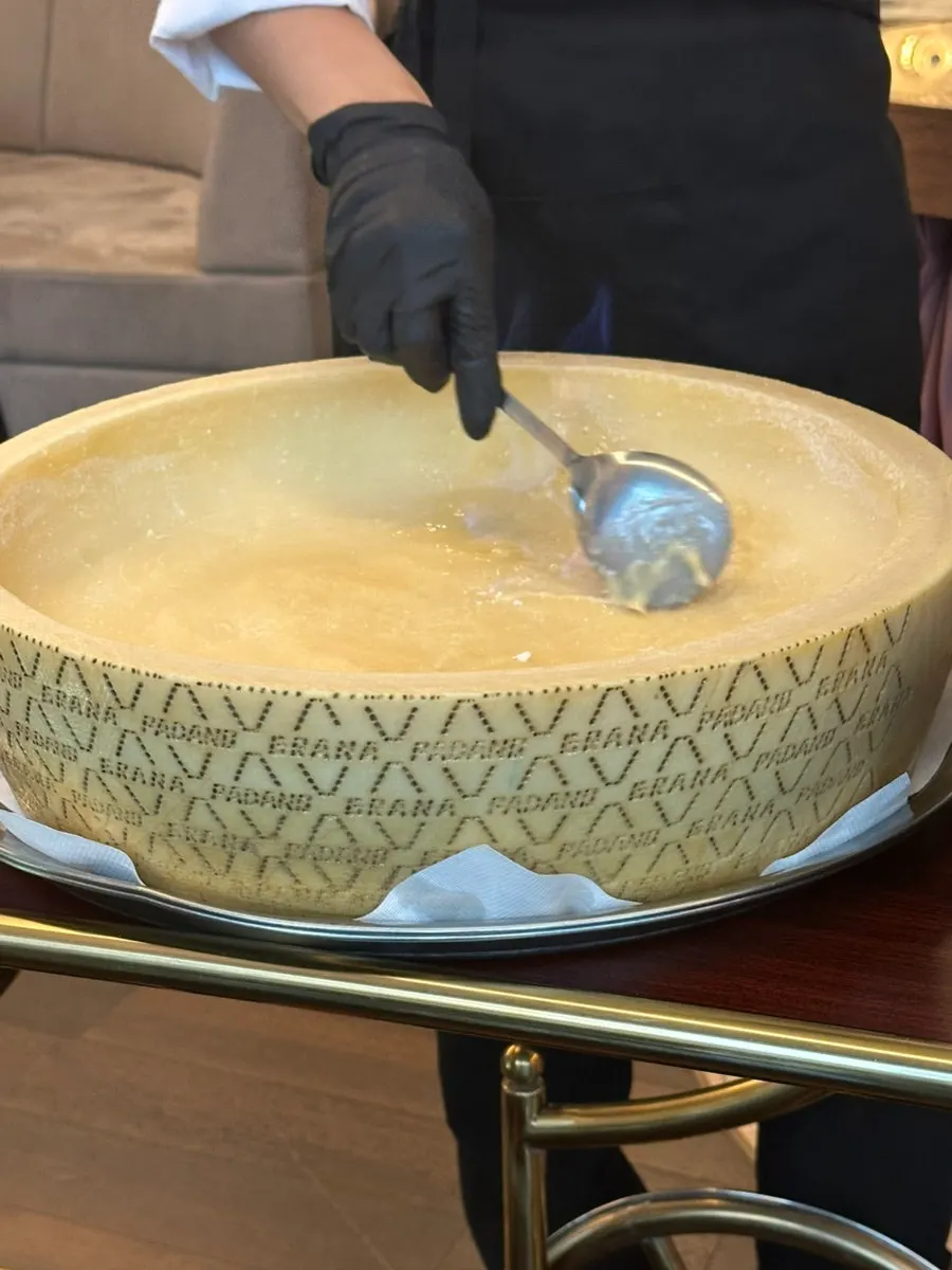 A plate of truffle cheese wheel tagliatelle