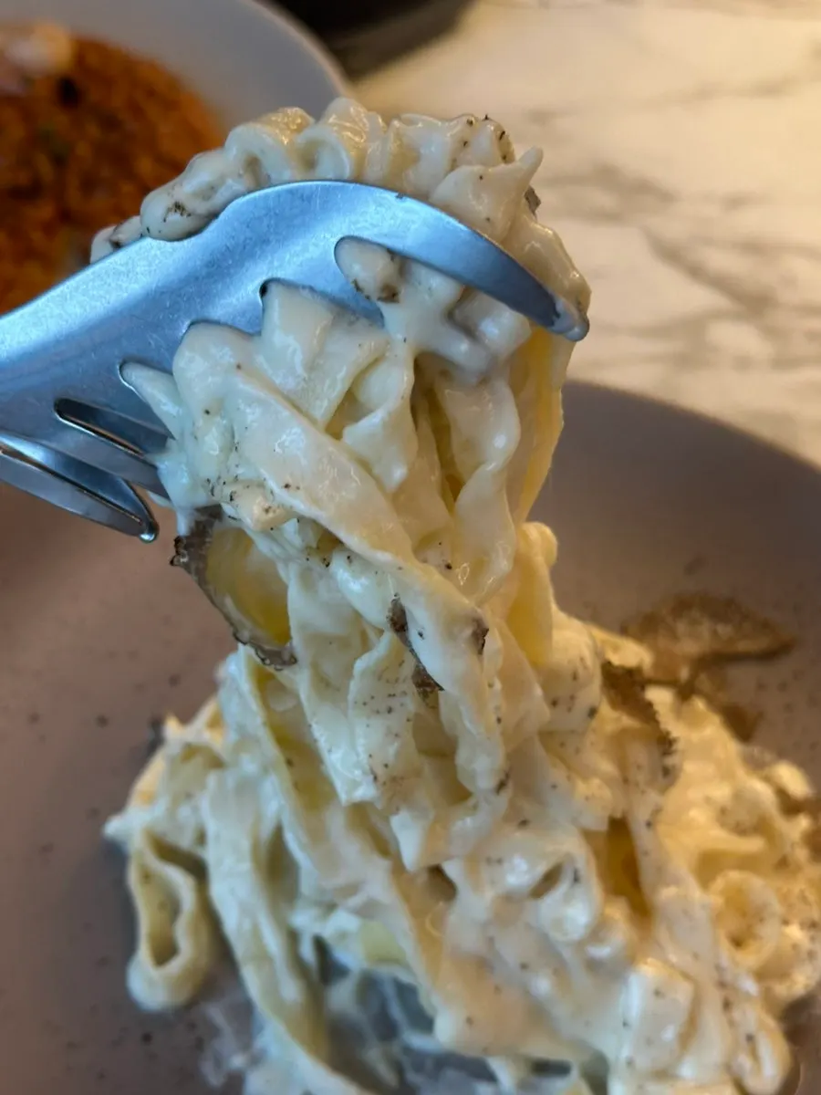 Lighting the cheese wheel to cook the pasta