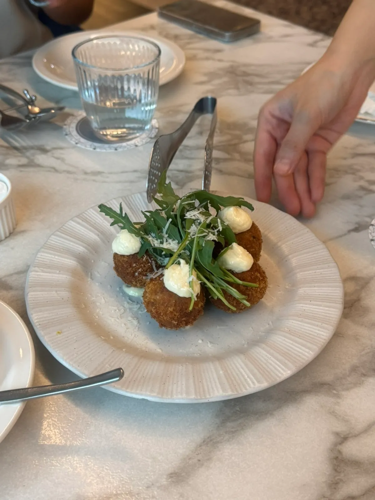 Bolognese arancini topped with rocket and cheese