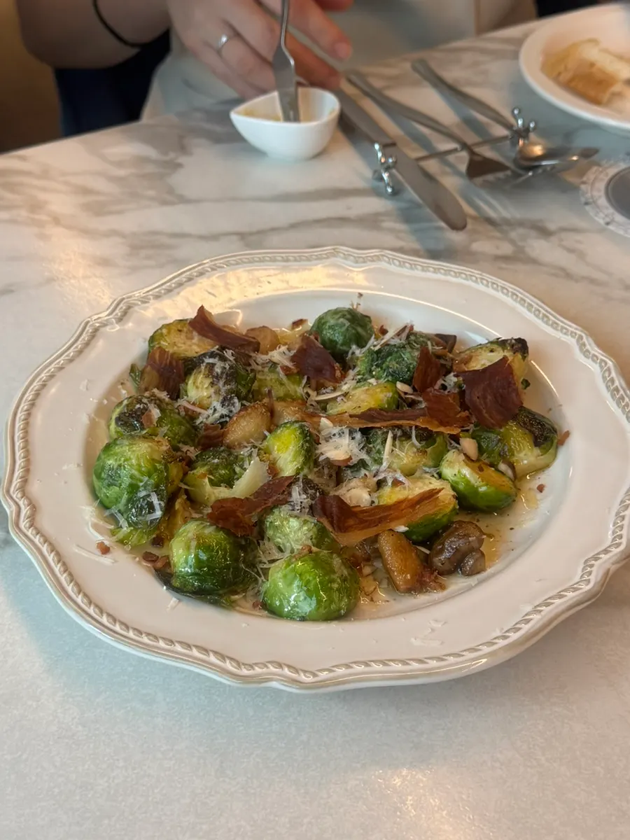 Roasted mini cabbage topped with prosciutto and cheese