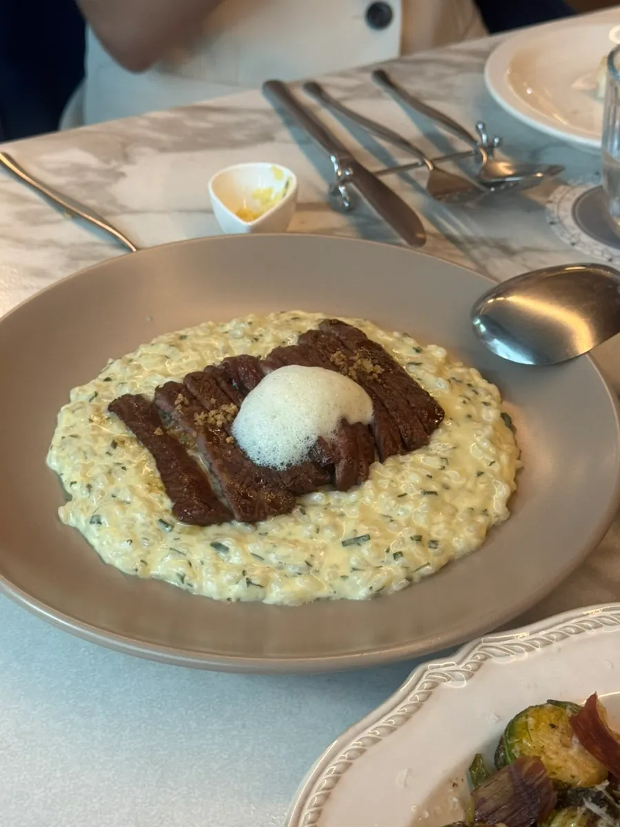 Prime chuck roll risotto topped with steak