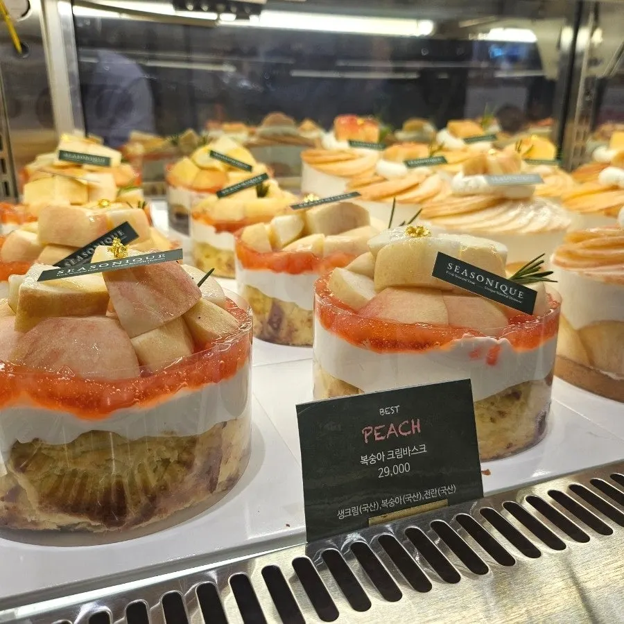 Siznique cakes topped with peach on display
